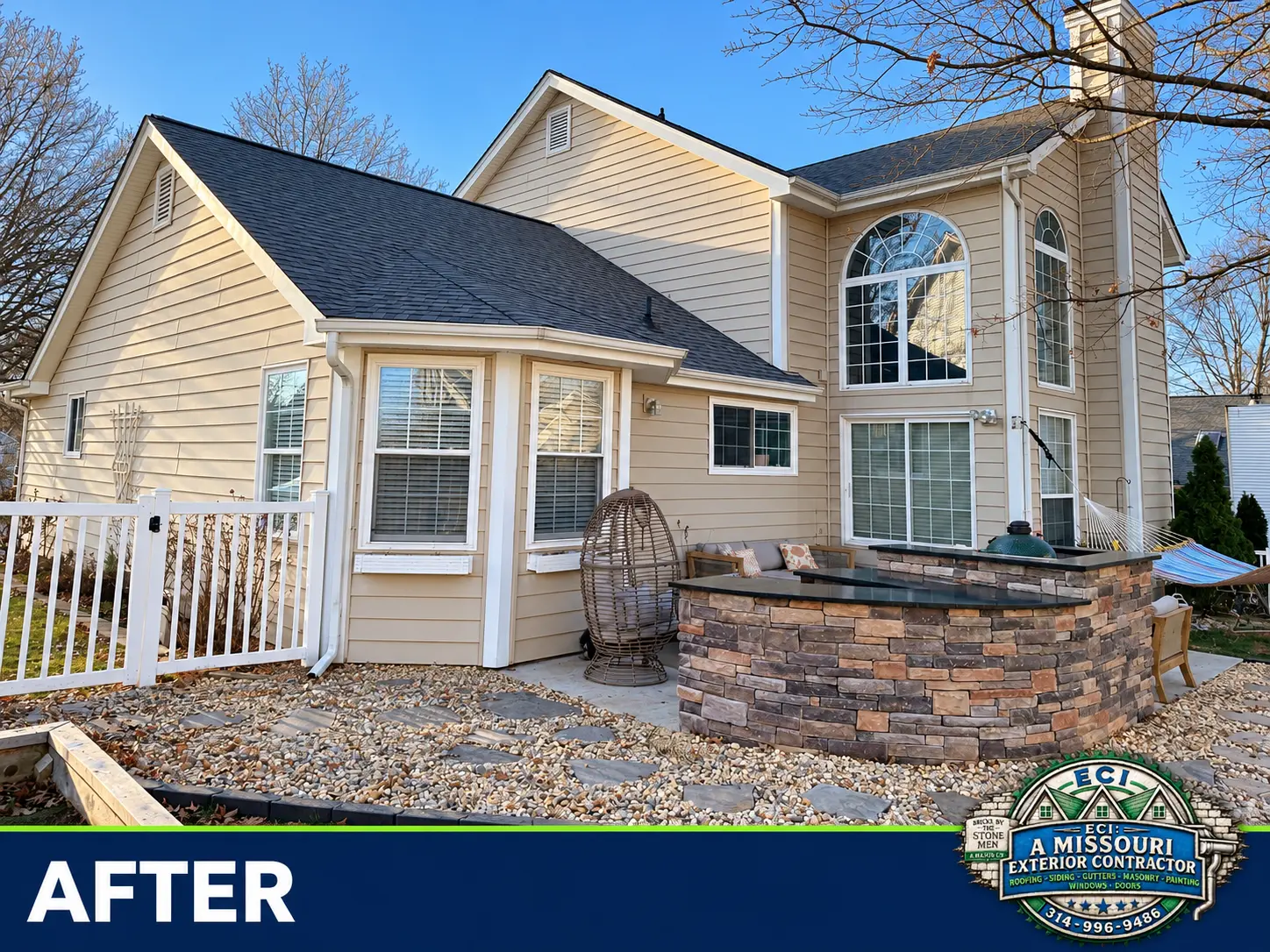 Completed stone outdoor kitchen and flagstone hardscape beside the home