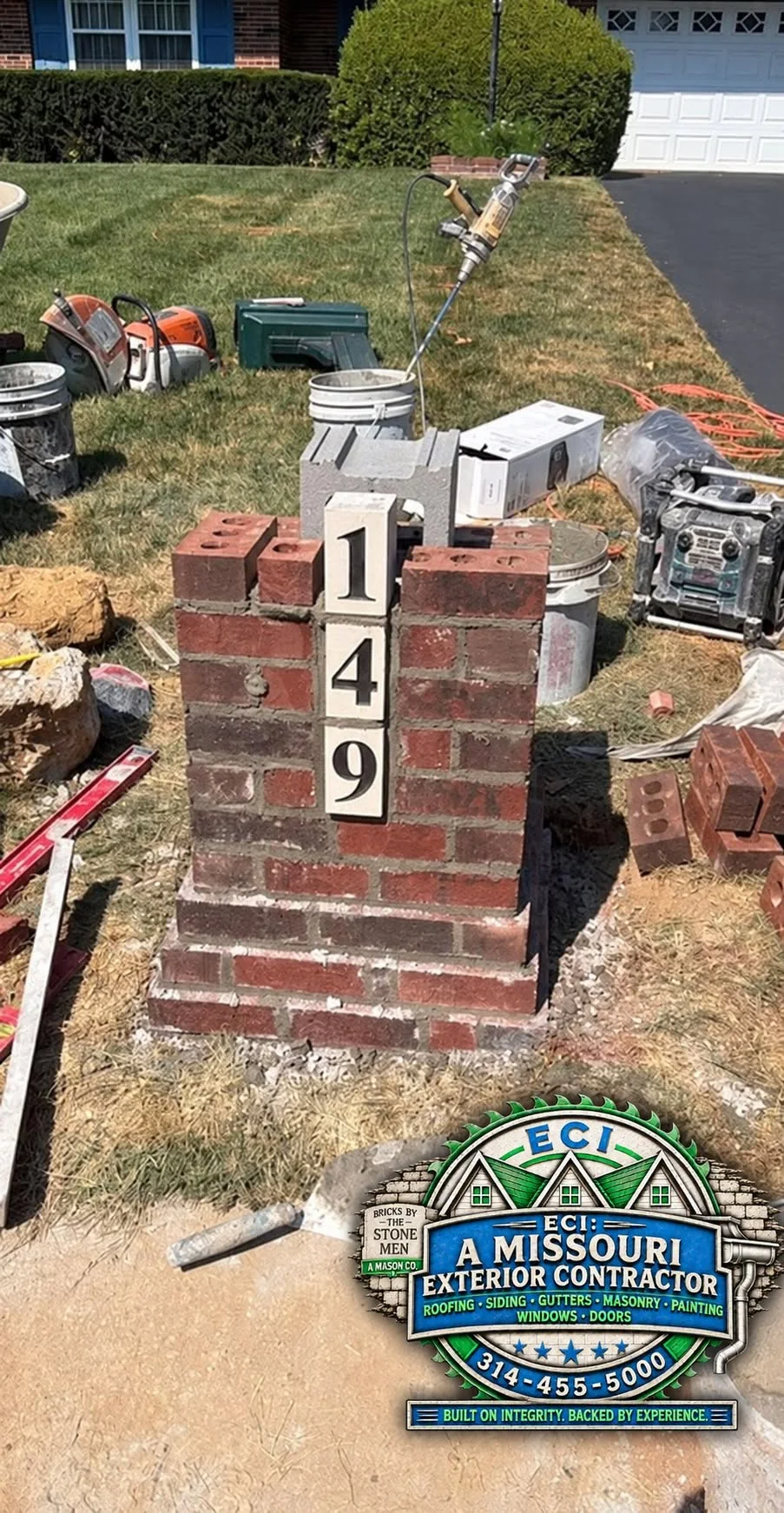 Partly built brick mailbox with tools at the worksite