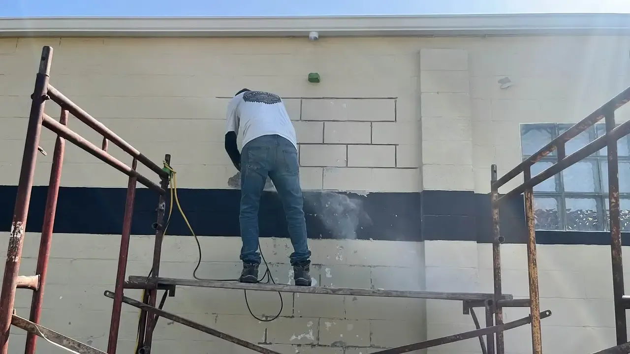 Worker restoring masonry on a commercial exterior wall