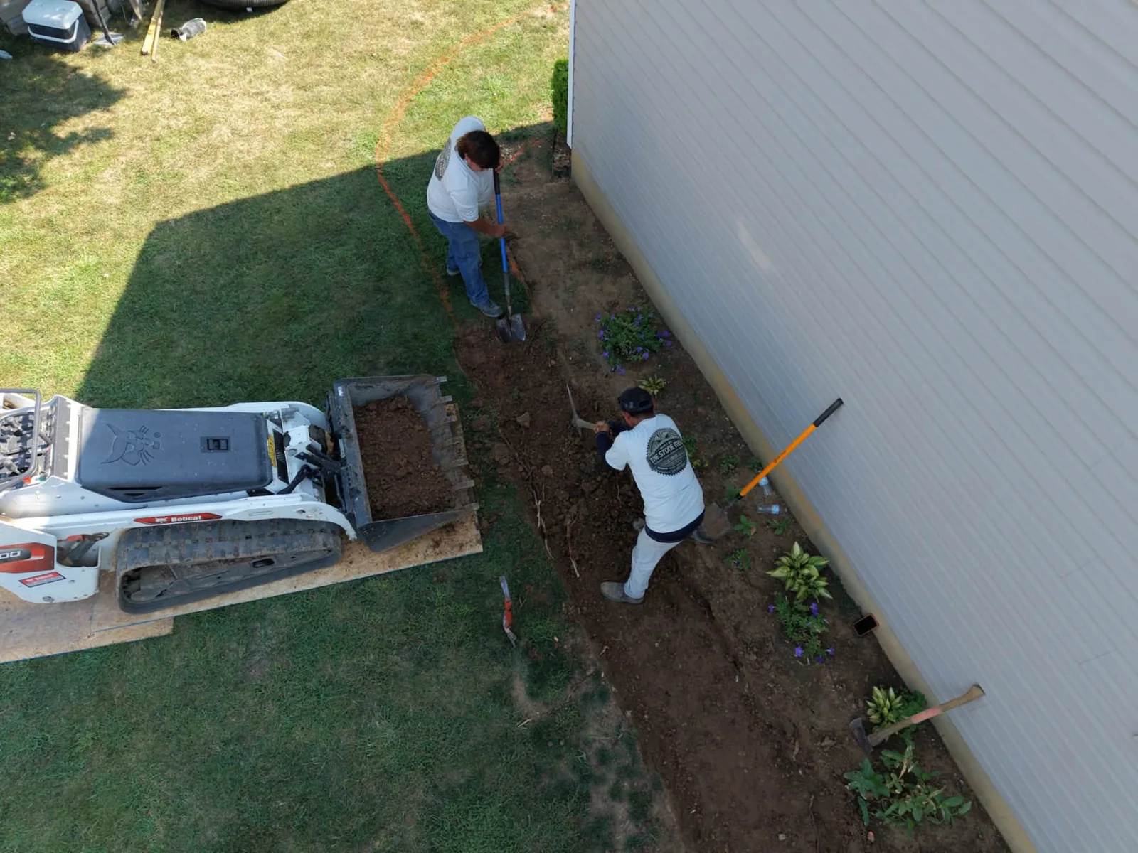 ECI crew preparing ground beside a home during a walkway project